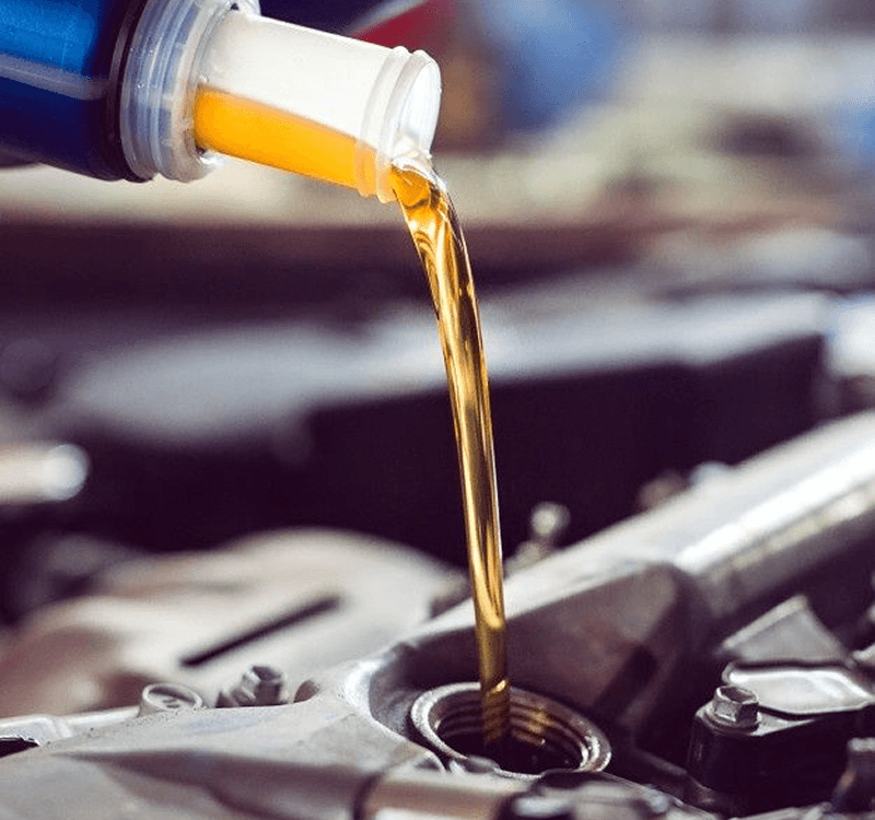 Engine oil being poured into the oil filler opening of a car engine